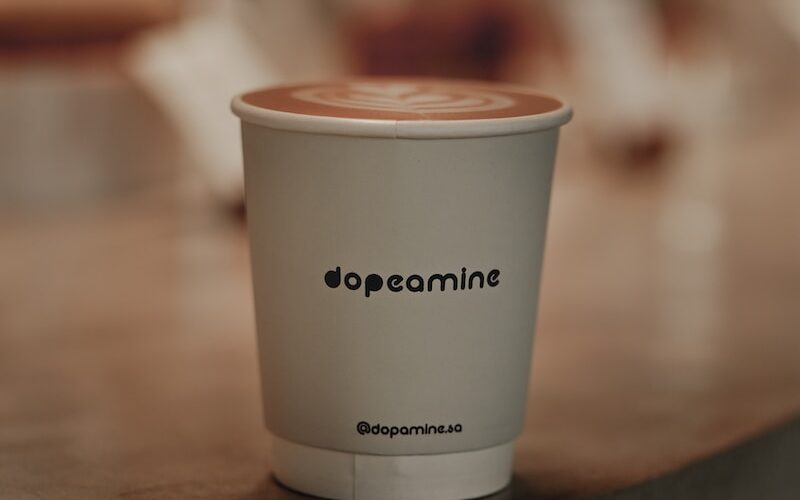 a white cup with a brown lid