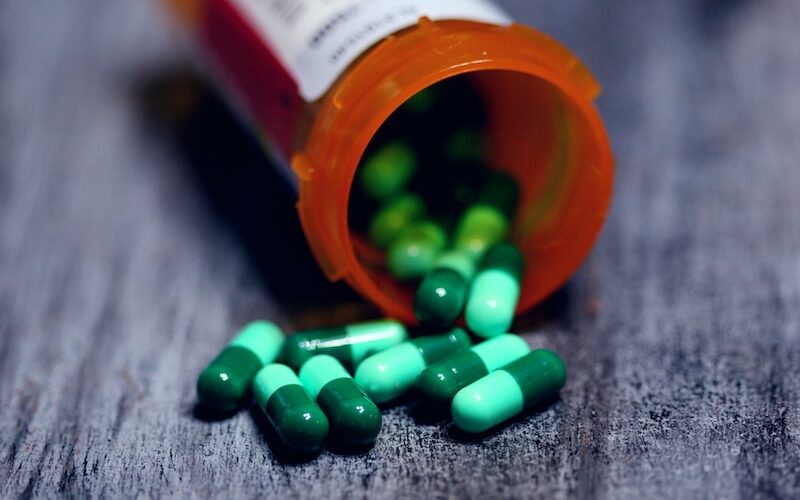 shallow focus photography of prescription bottle with capsules