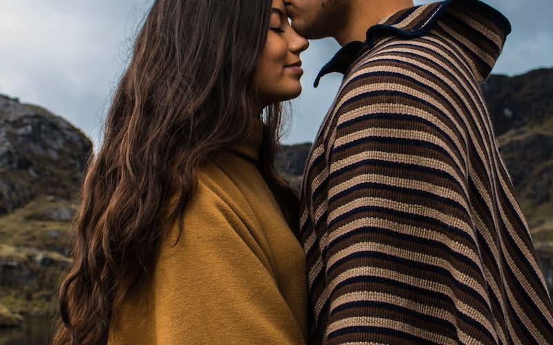 man kissing woman on forehead