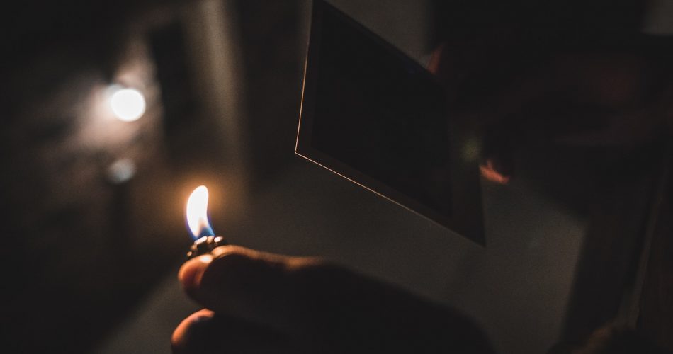 shallow focus photography of person holding a lighter