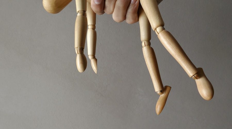 person holding brown wooden mannequin