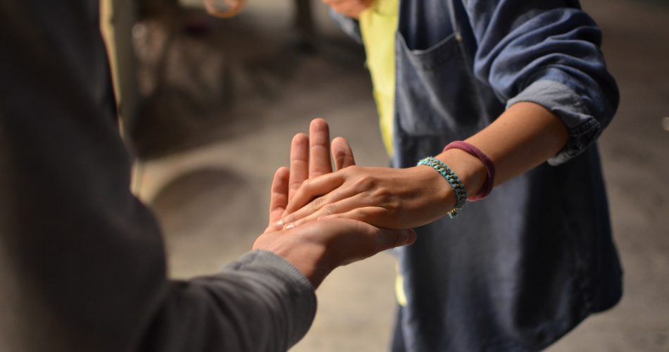 man and woman holding hands on street