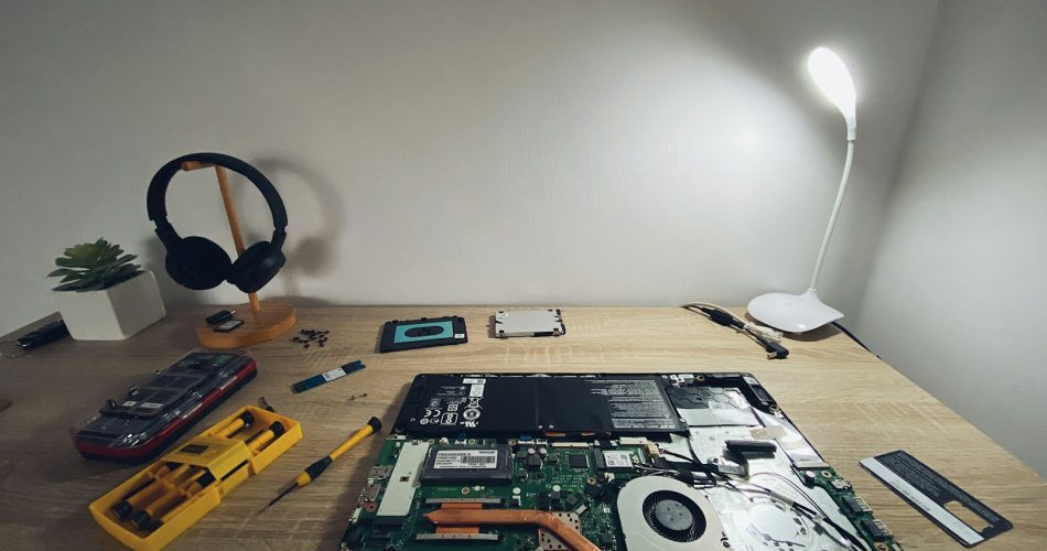 a table with a laptop and headphones on it